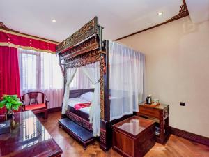 成都汉室酒店(成都锦里武侯祠店)的一间卧室配有天蓬床和玻璃桌