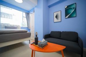 香港Student Accommodation - 276 Gloucester Road的蓝色的客厅配有沙发和桌子