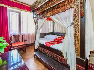 成都汉室酒店(成都锦里武侯祠店)的一间卧室配有一张带玻璃桌的天蓬床