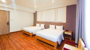 边和The Mansion Hotel Bien Hoa的酒店客房设有两张床和窗户。