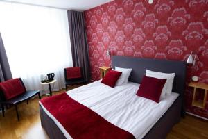 厄勒布鲁City Central Hotel Örebro by First Hotels的一间卧室设有一张带红色墙壁的大床