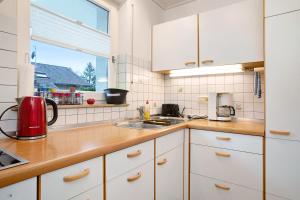 瓦瑟堡Haus Loser的厨房配有白色橱柜、水槽和窗户。
