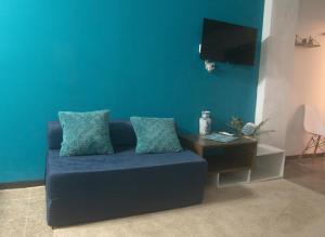 拉利伯塔德Acogedor con vista al mar的客厅配有一张蓝色的沙发,配有一张桌子