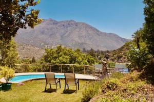 圣何塞德迈波Loft de montaña Los Guayacanes的两把椅子和一个山地游泳池