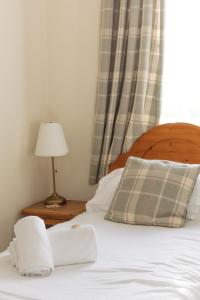HortonHorton Inn的一张带两个枕头的床和一张桌子上的台灯
