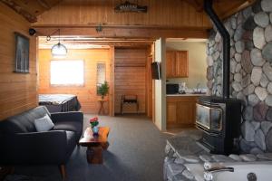 大熊湖2401 - Oak Knoll Studio with Jacuzzi #2 cabin的带沙发和石制壁炉的客厅