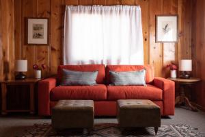 大熊湖2400-Oak Knoll Lodge cabin的客厅,窗户前设有红色沙发