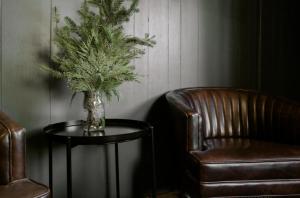 大熊湖2400-Oak Knoll Lodge cabin的椅子旁边的桌子上装有植物的花瓶