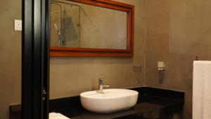 尼甘布Woodgrove Cabanas的浴室设有白色水槽和镜子
