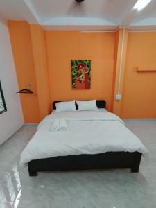 瓦拉纳西Ganga Putra Inn的一间卧室配有一张带橙色墙壁的大床