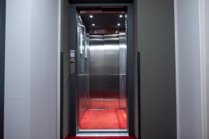 拉芬斯堡Pucci Bärengarten Stadthotel的走廊上铺有红地毯的电梯