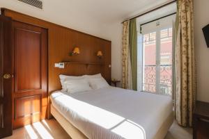 维拉·雷阿尔·德·桑托亚马尔克斯旅馆的卧室配有白色的床和窗户。