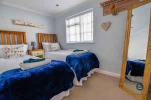 韦茅斯Seashells - Seaside Cottage 100m From Beach的一间卧室配有两张床和镜子