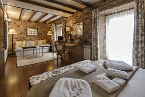 卡马里尼亚斯卢加尔多克塔里尼欧乡村酒店的一间卧室配有一张床和一张书桌,另一间卧室配有一张桌子。