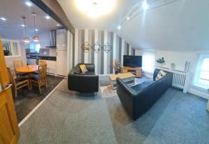 阿尔弗斯顿Ulverston Town Centre Flat (2 Bedrooms)的客厅配有沙发和桌子