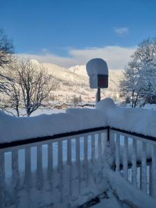 滕嫩山麓圣马丁Boutique Hotel Alpenhof的雪覆盖的栅栏,上面有时钟