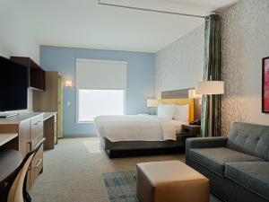 亚特兰大Home2 Suites By Hilton Atlanta Airport College Park的酒店客房,配有床和沙发