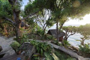 Nosy KombaNosy Komba Lodge的海滩上的度假村,种有树木和海洋