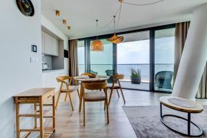 米兹多洛杰Wave Panorama Apartment - Sea View&SPA的厨房以及带桌椅的用餐室。