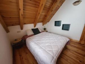 博西Duplex en la Vall de Boí, plena naturaza的阁楼上的卧室配有一张大床