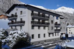 圣安东阿尔贝格Quality Hosts Arlberg - Hotel Goldenes Kreuz B&B的一座白色的大建筑,地面上积雪