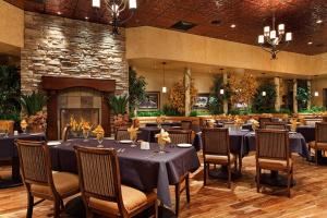 埃尔科Maverick Hotel and Casino by Red Lion Hotels的一间带桌椅和壁炉的用餐室