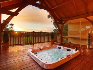AlzonneCabane de Prestige avec Jacuzzi et Sauna privatifs的房屋甲板上的热水浴池