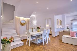 圣斯特凡诺斯Elena Luxury Suite Agios Stefanos的用餐室以及带桌椅的起居室。
