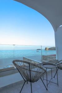 阿彻奇洛斯Delfini Beach Hotel & Suites的海景阳台上的桌椅