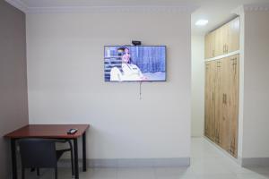 瓜亚基尔Hotel Murali - Cerca del Aeropuerto de Guayaquil的一间设有桌子和墙上电视的房间