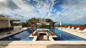 女人岛Villa Azul Maya的一个带椅子的游泳池和一个凉亭