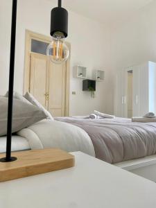 巴勒莫Urban poet retreat的白色卧室配有一张大床和吊灯