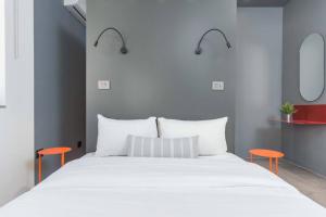 贝鲁特The Club 1-Bedroom Apartment in Gemmayze的一间卧室配有白色的床和两张橙色椅子