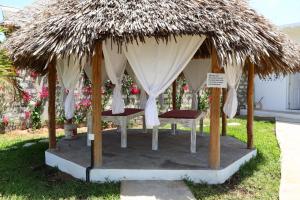 瓦塔穆Rafiki Jua Resort的凉亭配有两张床和茅草屋顶