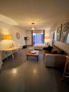 滨海萨纳里Superbe studio 34m2 avec terrasse aperçu mer的客厅配有沙发和桌子