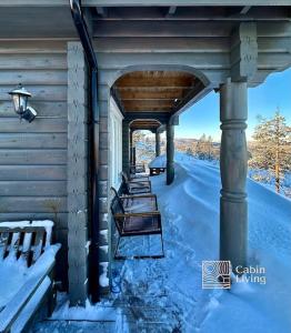 兰帕兰德Cozy cabin with incredible views and sauna的一组椅子坐在雪地的门廊上