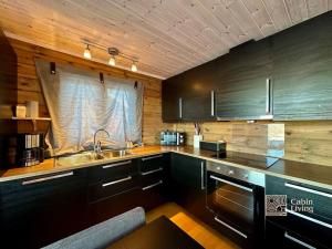 兰帕兰德Cozy cabin with incredible views and sauna的厨房配有黑色橱柜和水槽