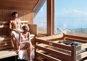 沙博伊茨Hotel Gran BelVeder & Ostsee Therme Resort & Spa的坐在桑拿里的男女