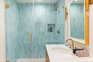 洛杉矶Sycamore Villa II的蓝色瓷砖浴室设有水槽和镜子