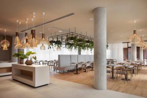 奥西耶克Hotel Materra的用餐室配有桌椅和吊灯。