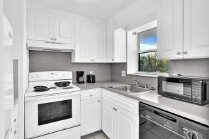 好莱坞Coastal Sunset的白色的厨房配有白色橱柜和水槽