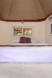 弗洛勒斯Paraíso Nimah的配有2扇窗户的客房内一张大白床