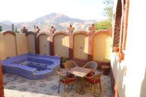 ‘Ezbet Abu ḤabashiMountain View House的一个带桌椅和热水浴池的庭院