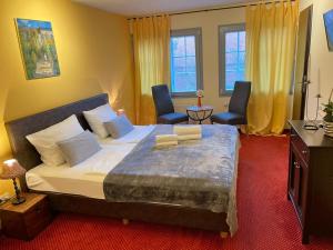 巴特塞格贝格Hotel Restaurant Iris的一间卧室配有一张大床和两把椅子