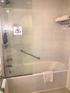 沙姆沙伊赫沙姆喜来登Spa别墅度假酒店的带浴缸的浴室,玻璃上标有标志
