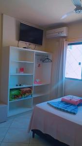马夫拉Pousadas Mafra的卧室配有一张床,墙上配有电视。