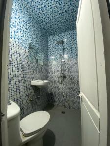 马拉喀什Hotel Dar Youssef 1的蓝色瓷砖浴室设有卫生间和水槽