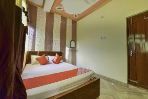 BihtaOYO Flagship Ashoka Guest House的小卧室配有红色枕头的床