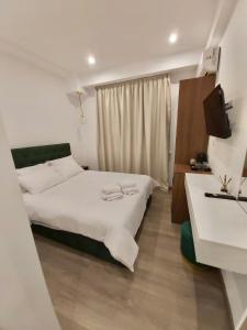 雅典Real City Suites Syntagma的一间卧室配有两张床和电视。