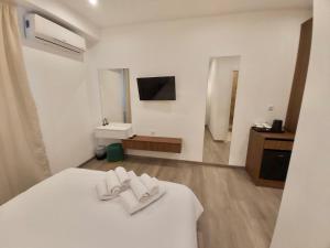 雅典Real City Suites Syntagma的卧室配有白色床和毛巾
